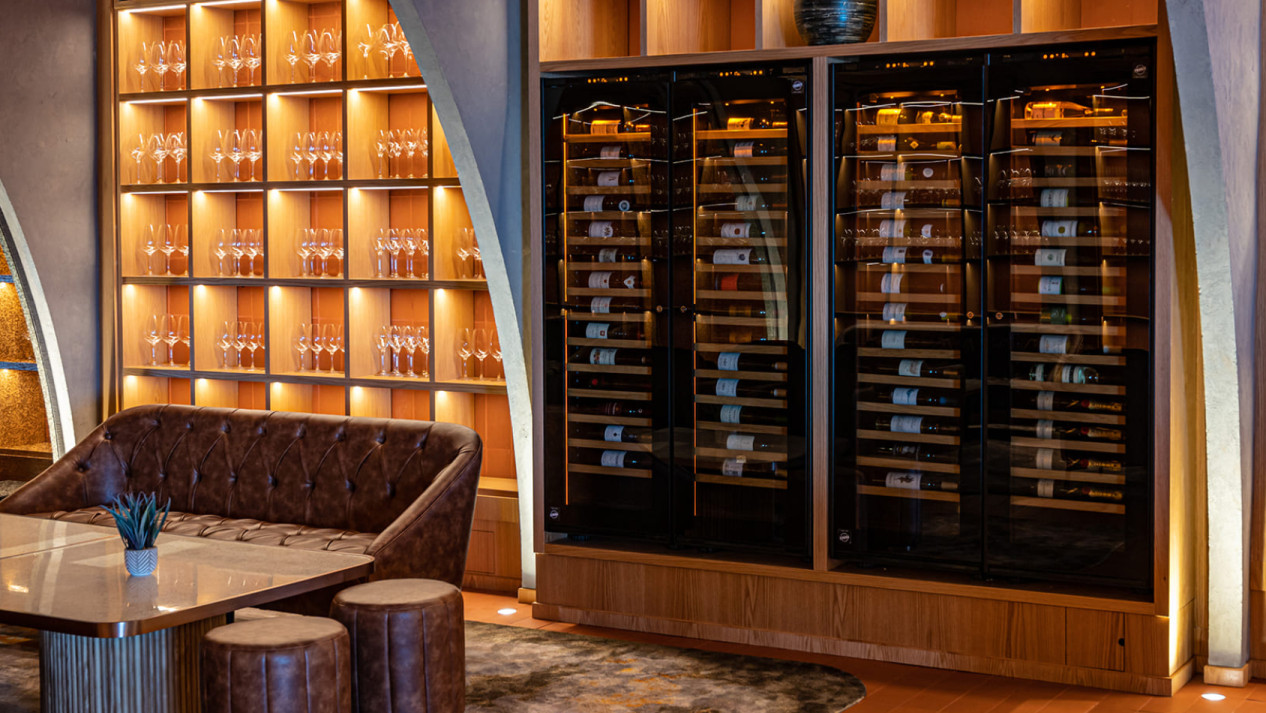 Weinwand mit vier großen integrierten Weinkhülschränk – Inszenierung des Weinangebots in der Dekoration eines Restaurants. Inspiration EuroCave